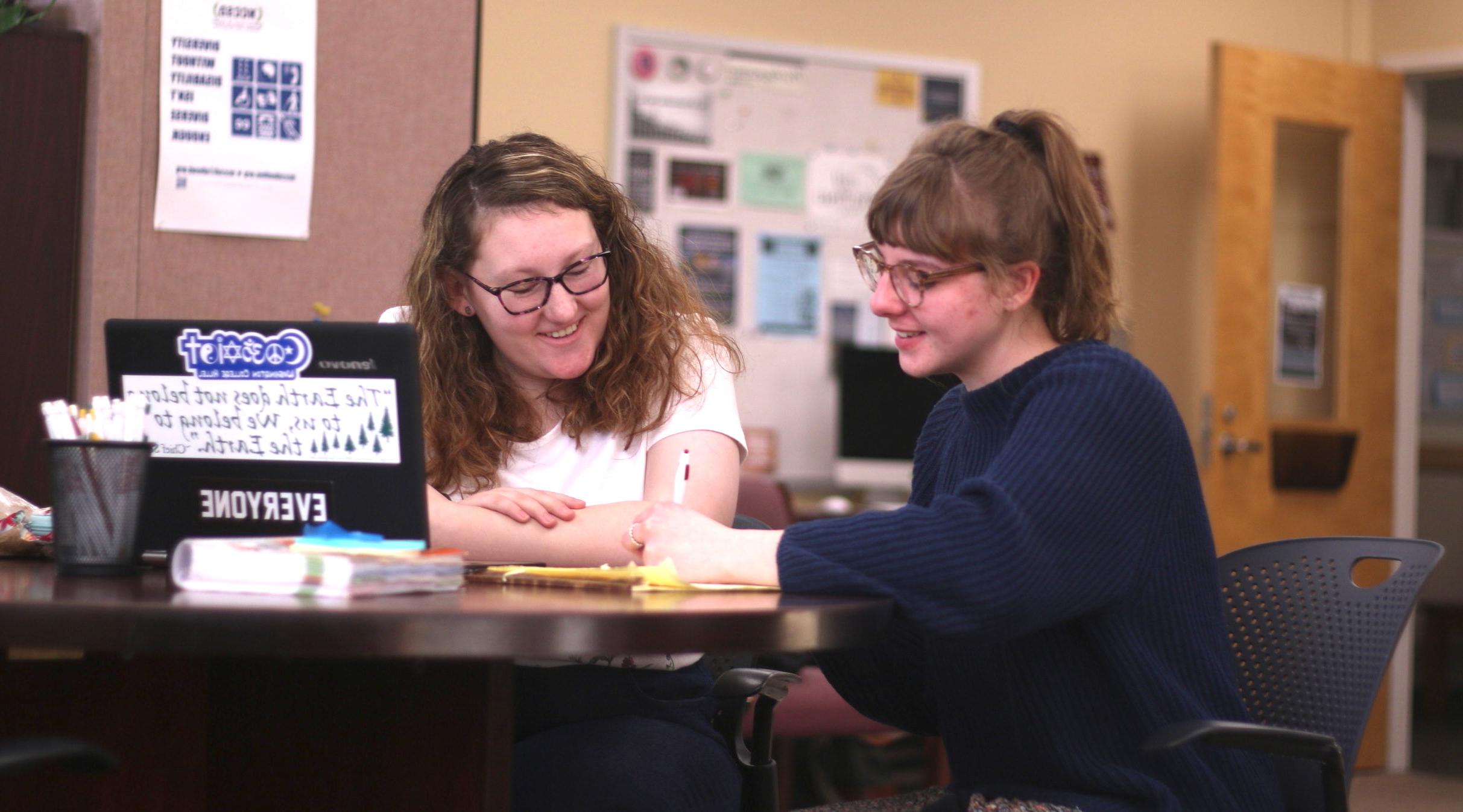 Two people sitting in the writing center